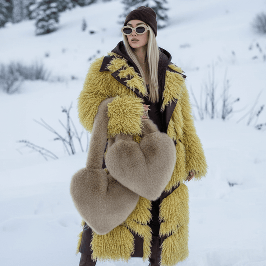 Person wearing a yellow fluffy coat and brown beanie in a snowy landscape