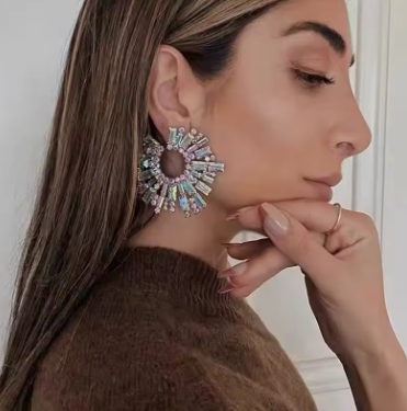 Woman wearing a large, decorative earring with a neutral background