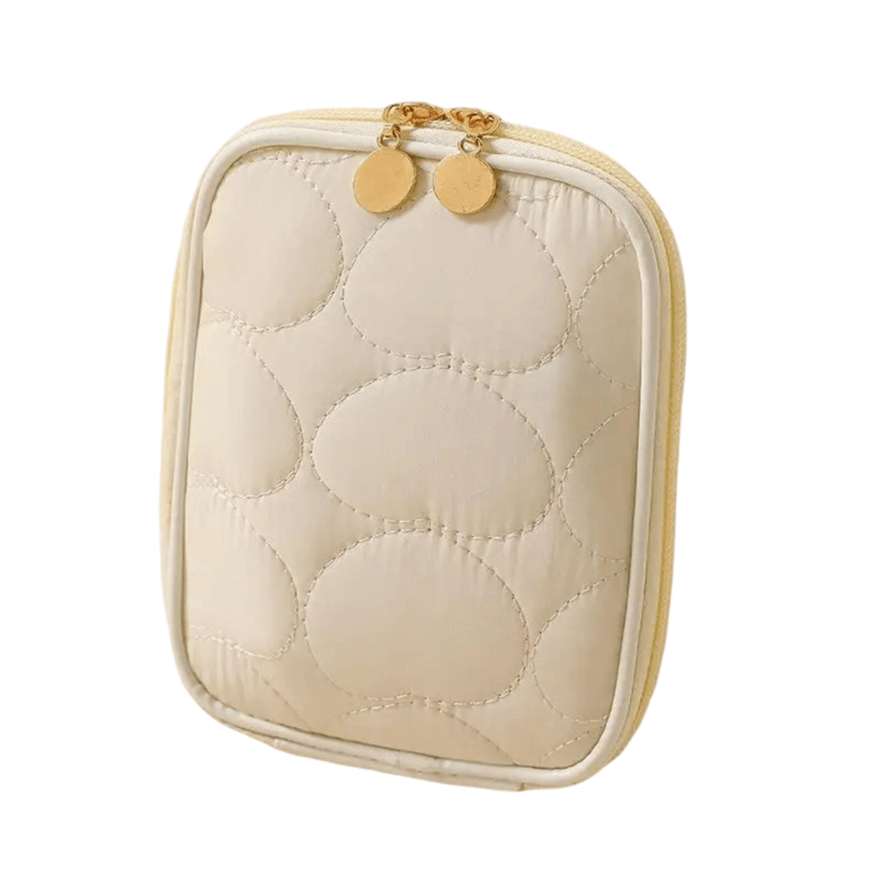 Quilted beige jewelry case with gold accents on a white background