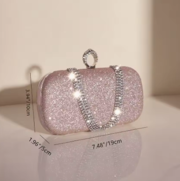Pink glittery clutch bag with measurements on a light background