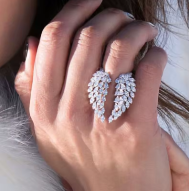 Close-up of a hand wearing a sparkling silver earring with a blurred background
