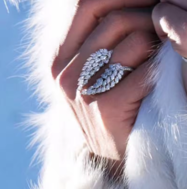 Close-up of a hand wearing a decorative ring with a fur coat and blue sky background