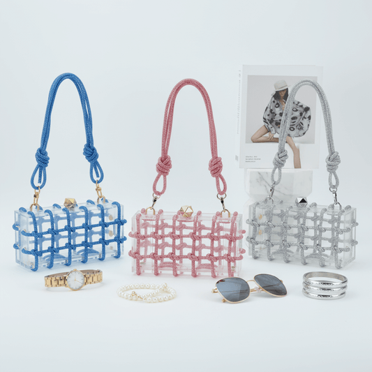 Three small handbags in blue, pink, and gray with accessories on a light background