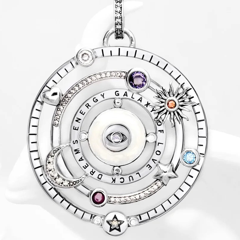 Silver pendant with gemstones on a white background.