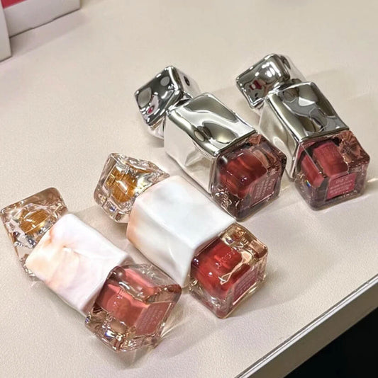 Set of nail polish bottles with metallic caps on a light surface