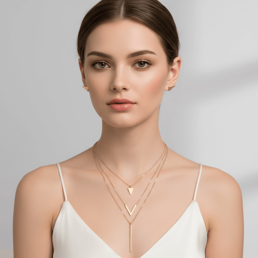 Woman wearing a gold necklace on a gray background