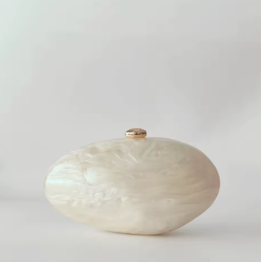 White textured vase with a gold accent on a light gray background