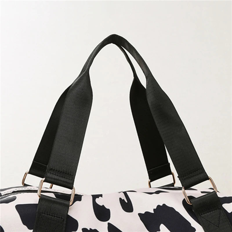 Close-up of a black strap on a white bag with black pattern
