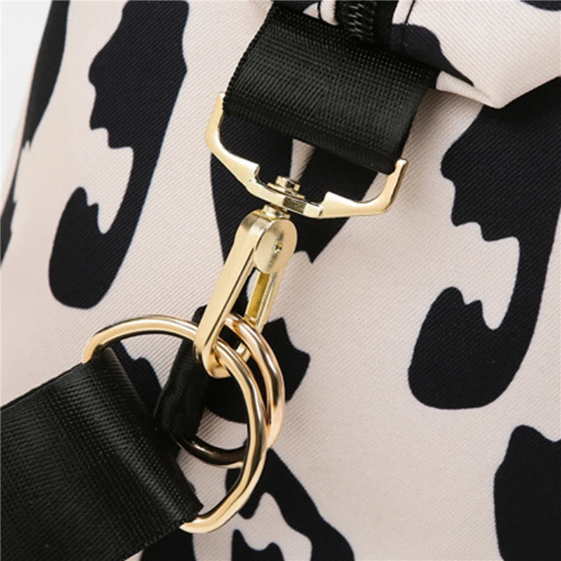 Close-up of a bag with black and white pattern and gold hardware.