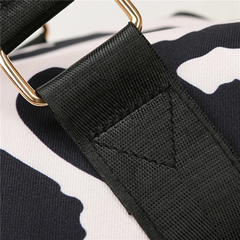 Close-up of a black strap with a gold buckle on a camouflage-patterned background